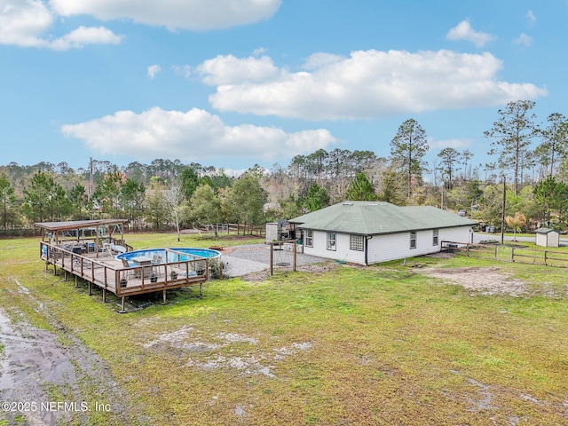 view of dock featuring a deck, a yard, and fence