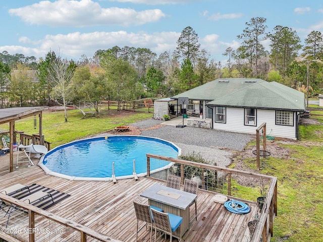 pool featuring a lawn, a deck, and fence