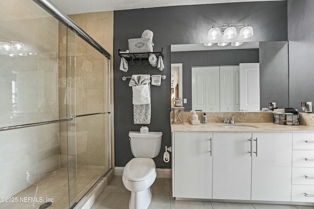 bathroom with a closet, a shower stall, vanity, and tile patterned floors