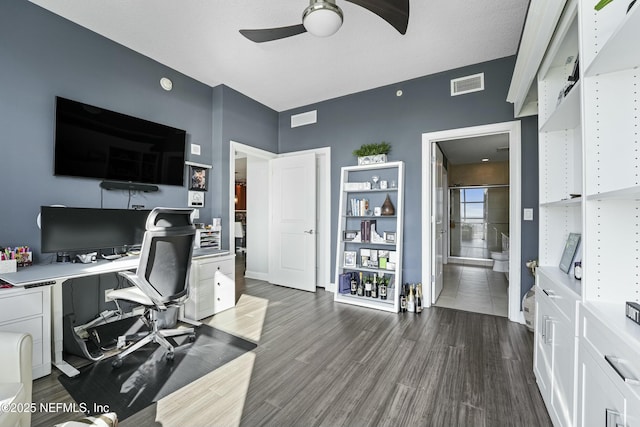 office area featuring a ceiling fan, dark wood-style flooring, and visible vents