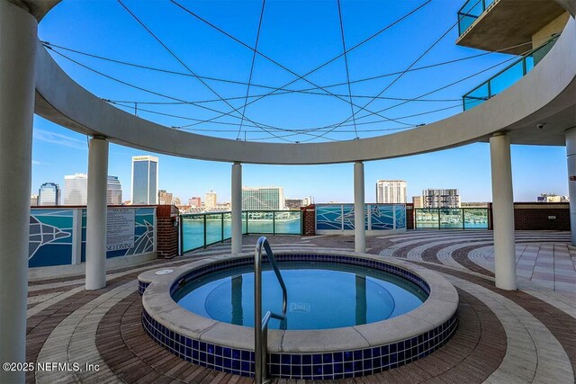 view of pool with a view of city and a hot tub