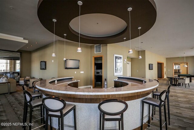 kitchen with open floor plan, dark wood finished floors, visible vents, and decorative light fixtures