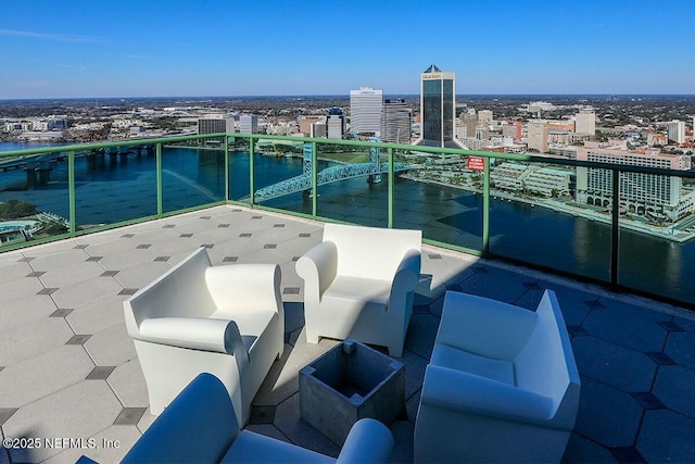 view of patio / terrace featuring a city view, a water view, and a balcony