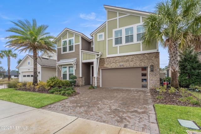 view of front of property featuring a garage, decorative driveway, and brick siding