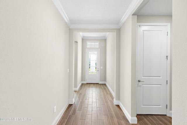 doorway featuring ornamental molding, wood finish floors, and baseboards