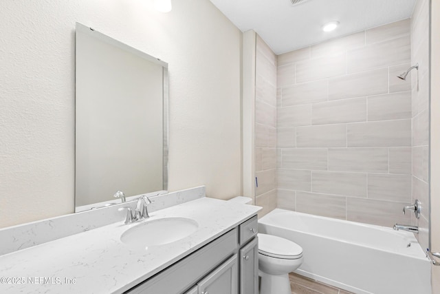 bathroom with vanity, bathtub / shower combination, and toilet