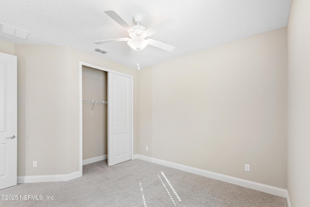 unfurnished bedroom with light carpet, baseboards, visible vents, a ceiling fan, and a closet