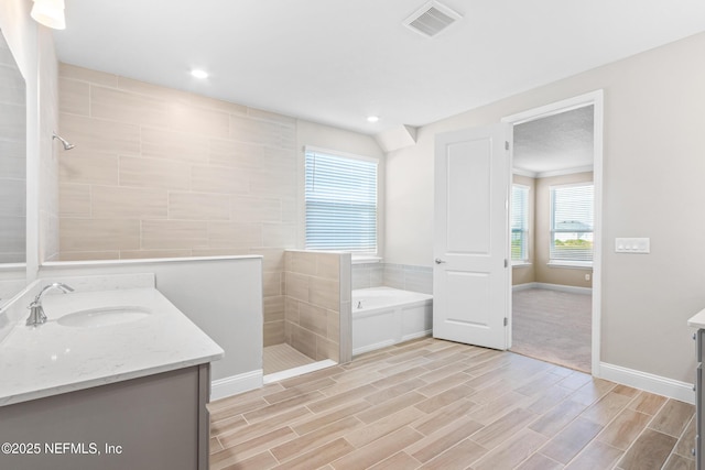 full bathroom featuring a walk in shower, wood finish floors, vanity, visible vents, and a bath