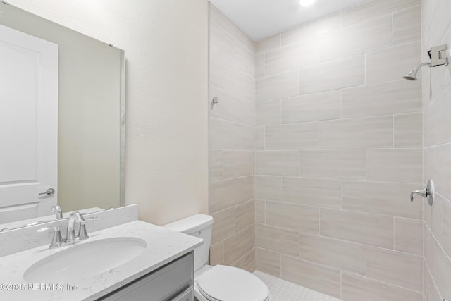 bathroom featuring vanity, a shower stall, and toilet