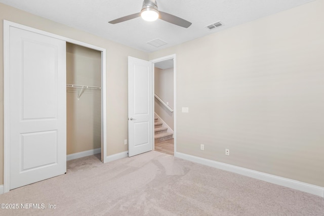 unfurnished bedroom with ceiling fan, light carpet, visible vents, baseboards, and a closet