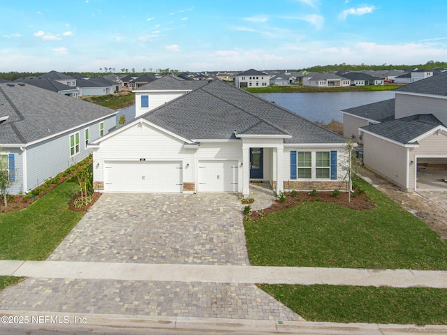 view of front of house featuring a garage, a front yard, decorative driveway, and a residential view