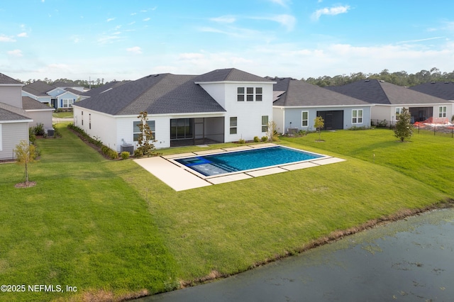 outdoor pool featuring cooling unit, a lawn, a residential view, and a patio