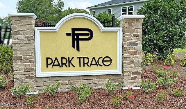 community / neighborhood sign featuring fence