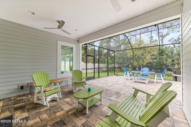 view of patio / terrace with a ceiling fan, outdoor dining area, glass enclosure, and fence