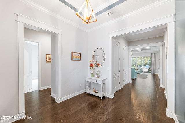 corridor featuring a notable chandelier, dark wood-style flooring, visible vents, baseboards, and ornamental molding