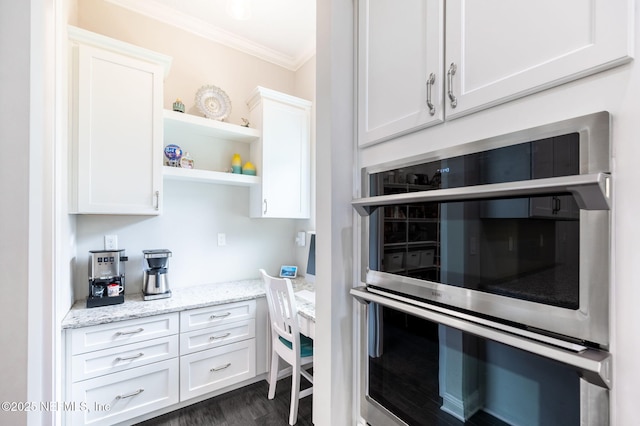 kitchen featuring white cabinets, ornamental molding, light stone countertops, double oven, and open shelves