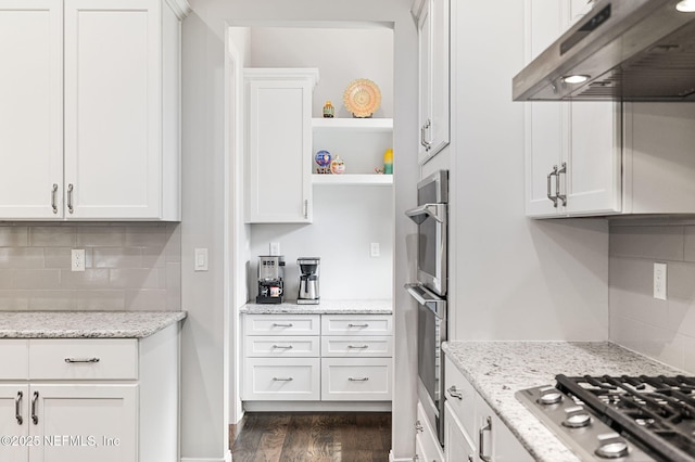 kitchen with light stone counters, appliances with stainless steel finishes, white cabinetry, and under cabinet range hood