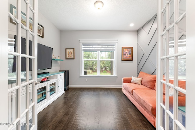 living area featuring a textured ceiling, french doors, dark wood-style flooring, and baseboards