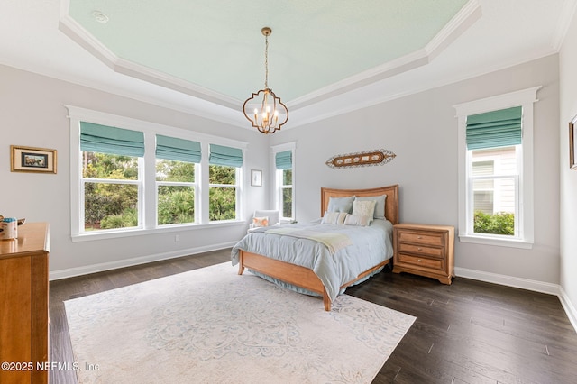 bedroom featuring crown molding, baseboards, a raised ceiling, and dark wood-type flooring