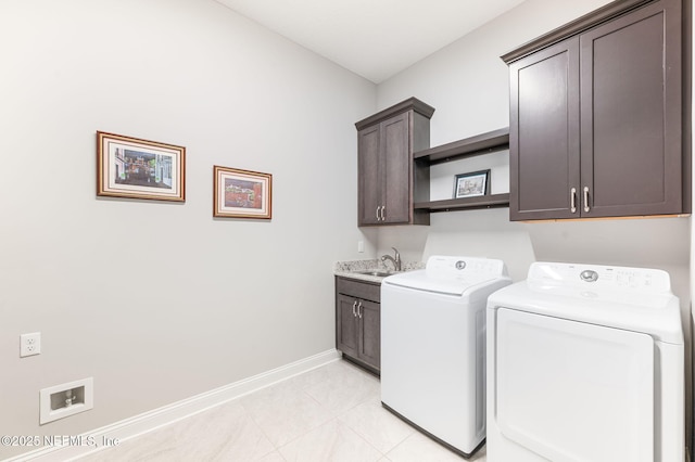 laundry area featuring cabinet space, light tile patterned flooring, a sink, independent washer and dryer, and baseboards