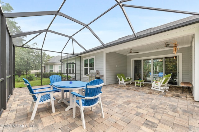 view of patio / terrace with glass enclosure, fence, and a ceiling fan