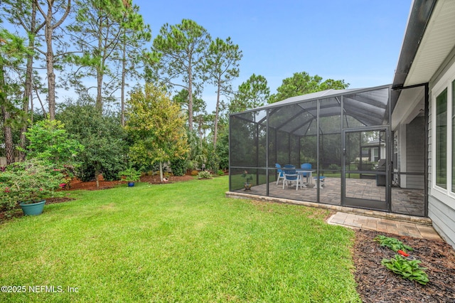 view of yard with glass enclosure and a patio