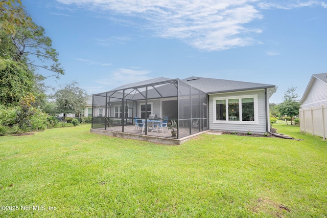 rear view of property with a lawn, a patio area, and a lanai