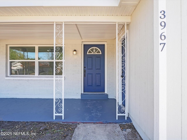 doorway to property featuring brick siding