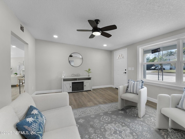 living room featuring baseboards, visible vents, a fireplace, and light wood finished floors