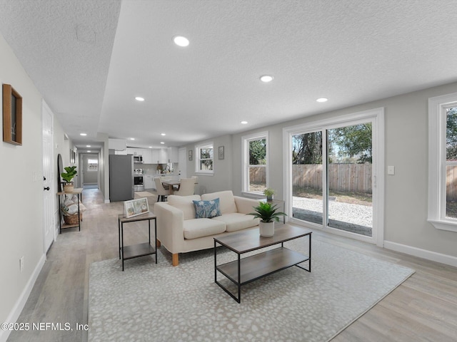 living area featuring recessed lighting, light wood-style flooring, and baseboards