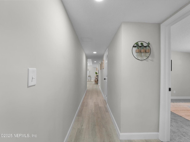 corridor featuring recessed lighting, light wood finished floors, and baseboards