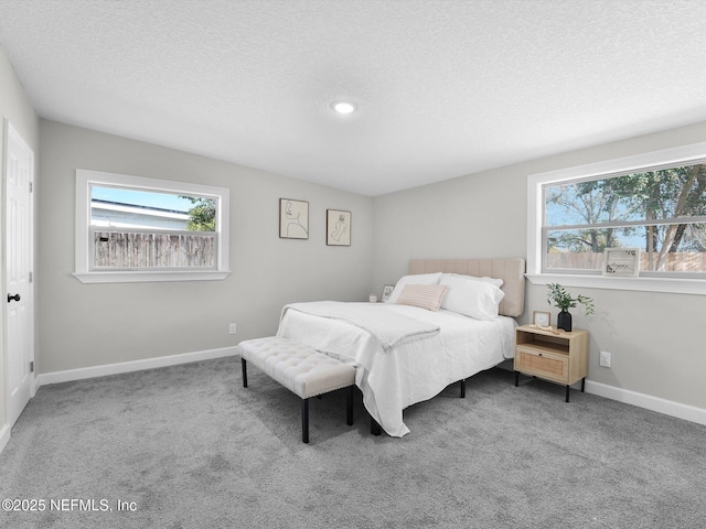 bedroom with a textured ceiling, carpet, and baseboards