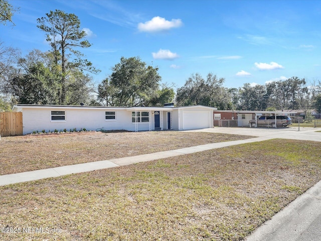 single story home featuring driveway, a garage, fence, a front lawn, and a carport