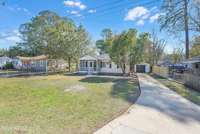 view of front of house with an outbuilding, fence, concrete driveway, crawl space, and a front yard