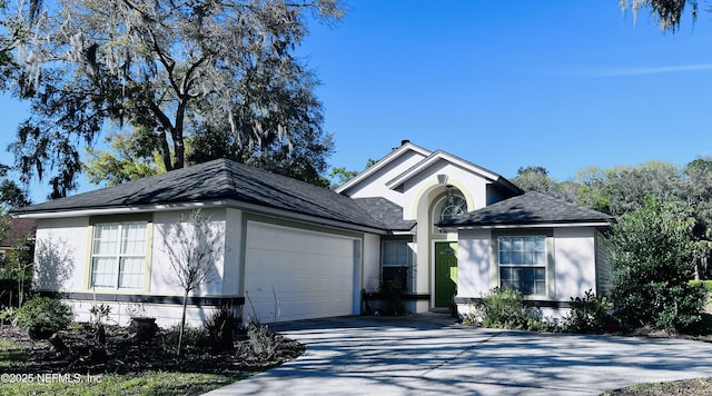 ranch-style house featuring concrete driveway, an attached garage, and stucco siding