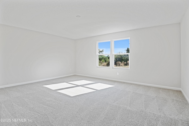 unfurnished room with carpet flooring, a textured ceiling, and baseboards