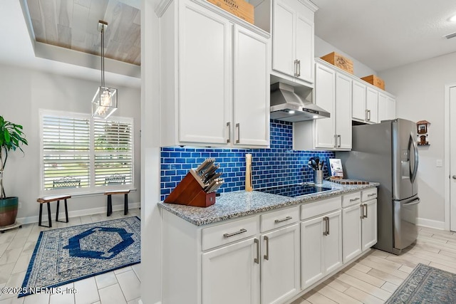 34072 Lavender Parke Dr, Fernandina Beach, FL 32034 - kitchen featuring tasteful backsplash, white cabinets, black electric stovetop, and exhaust hood