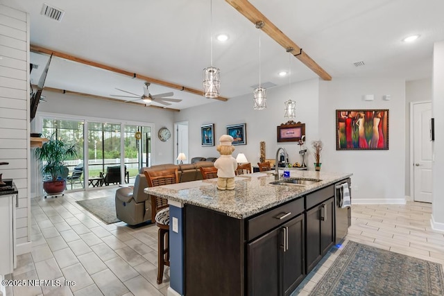 34072 Lavender Parke Dr, Fernandina Beach, FL 32034 - kitchen with decorative light fixtures, visible vents, open floor plan, a sink, and light stone countertops