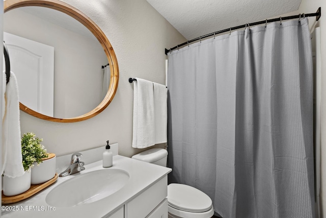 bathroom with toilet, curtained shower, a textured ceiling, and vanity