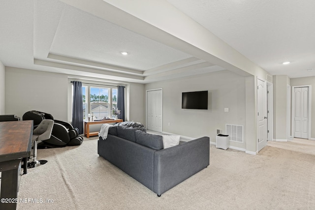 living area featuring recessed lighting, a raised ceiling, visible vents, light carpet, and baseboards