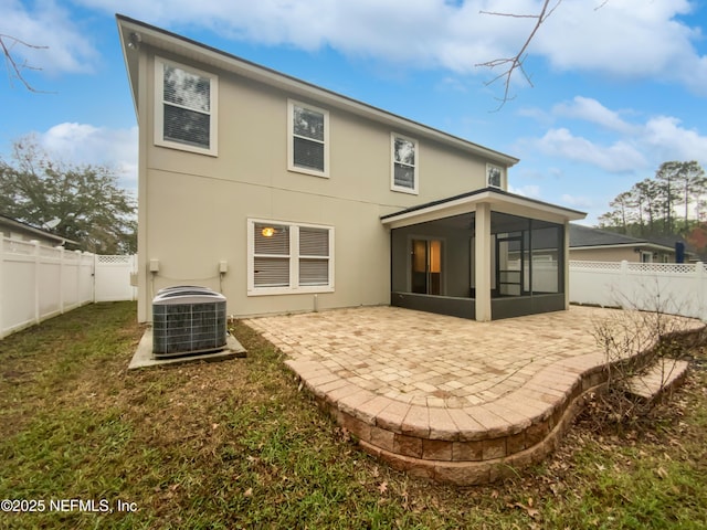 rear view of property with a sunroom, a fenced backyard, a patio, and central AC unit