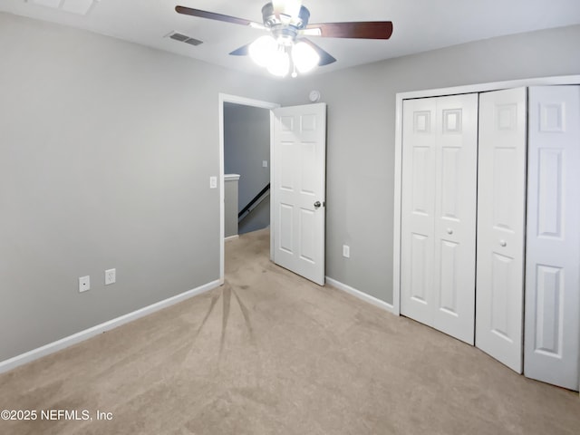 unfurnished bedroom with baseboards, a closet, visible vents, and light colored carpet