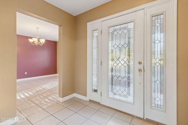 entrance foyer featuring light tile patterned floors, baseboards, and a notable chandelier