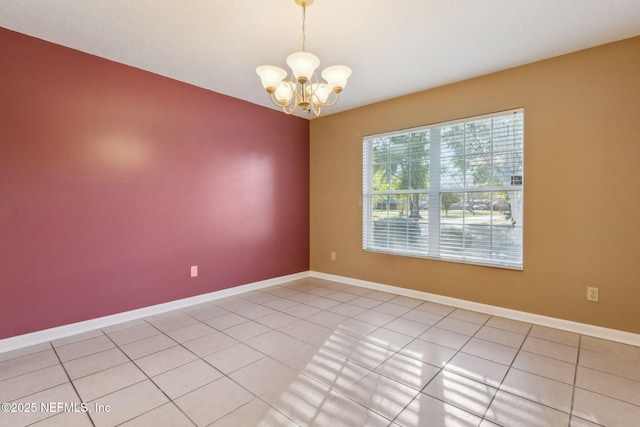 unfurnished room featuring an inviting chandelier, baseboards, and light tile patterned flooring