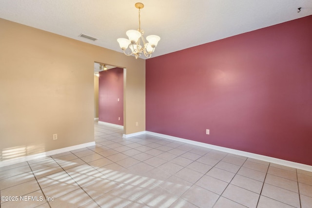 unfurnished room featuring visible vents, a notable chandelier, baseboards, and tile patterned floors