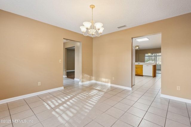 spare room with light tile patterned floors, a chandelier, visible vents, and baseboards