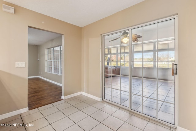 spare room with light tile patterned floors and baseboards