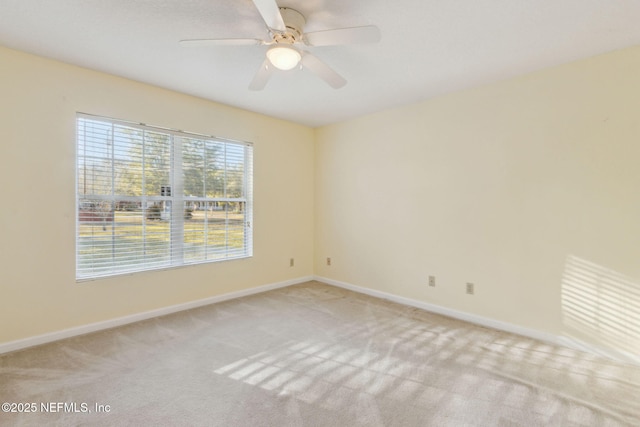 unfurnished room with light carpet, baseboards, and a ceiling fan