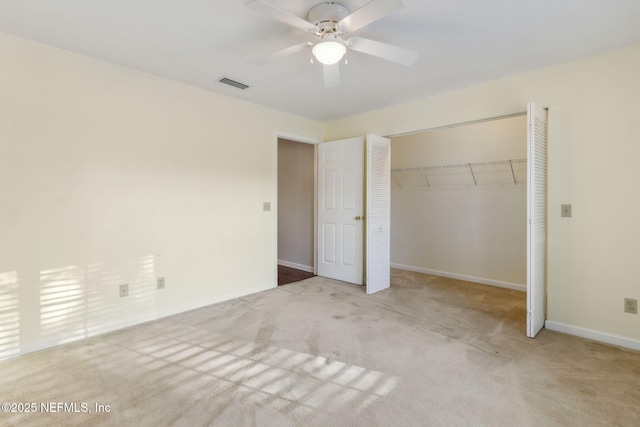 unfurnished bedroom with light carpet, a closet, visible vents, and baseboards