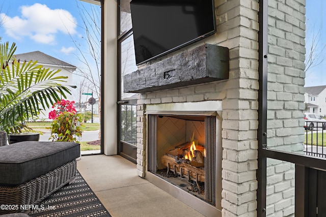 view of patio with an outdoor brick fireplace and an attached garage